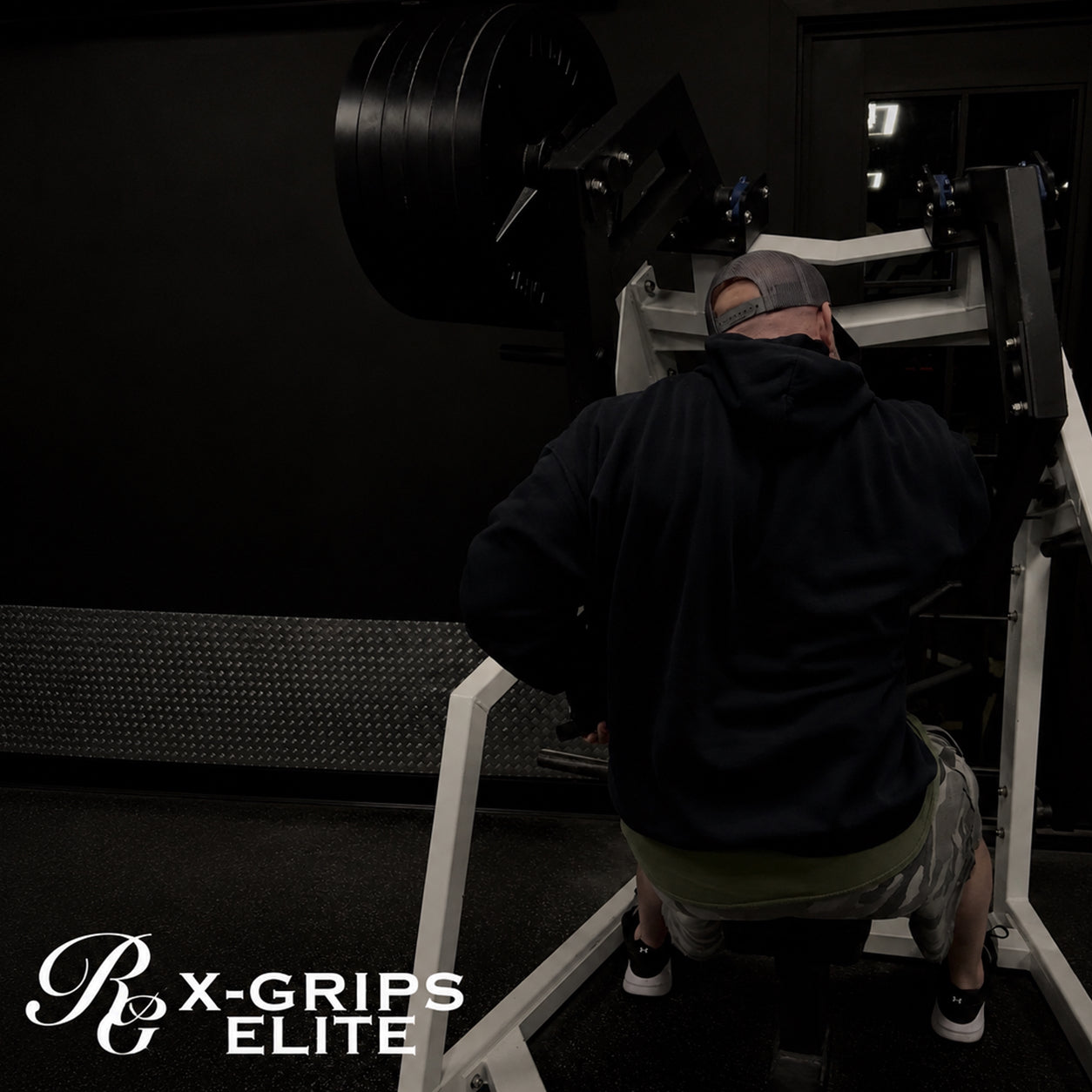 Person using a weight machine in a gym with 'X-Grips Elite' branding.