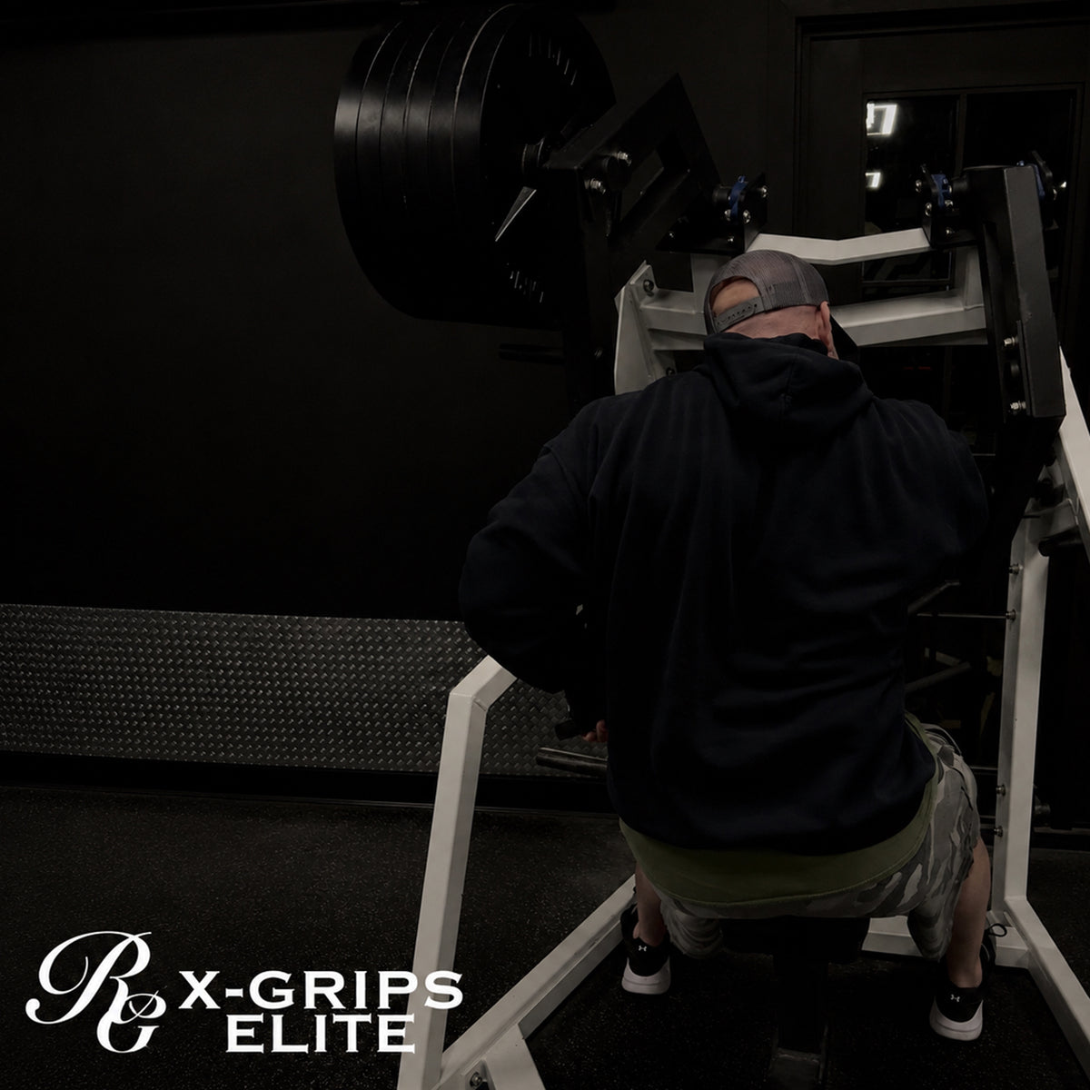 Person using a weight machine in a gym with 'X-Grips Elite' branding.